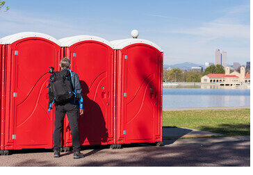 Row of portable restrooms staged in a Miami Beach public park