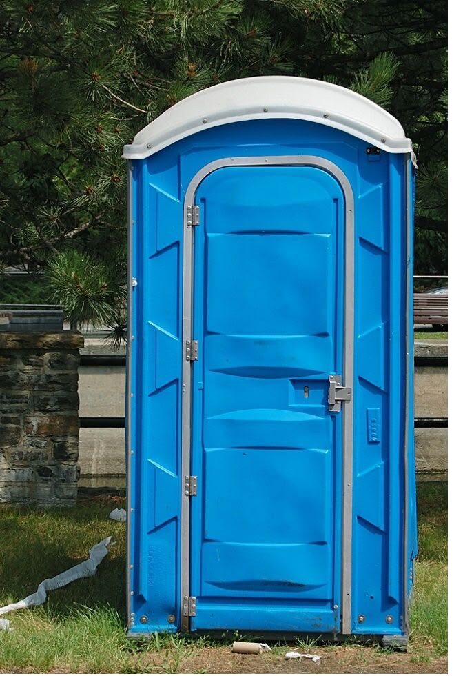 Portable toilet placed at a remote, long-term site surrounded by trees